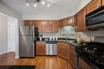 Renovated gourmet kitchens with maple cabinetry, granite countertops and brushed nickel hardware and fixtures